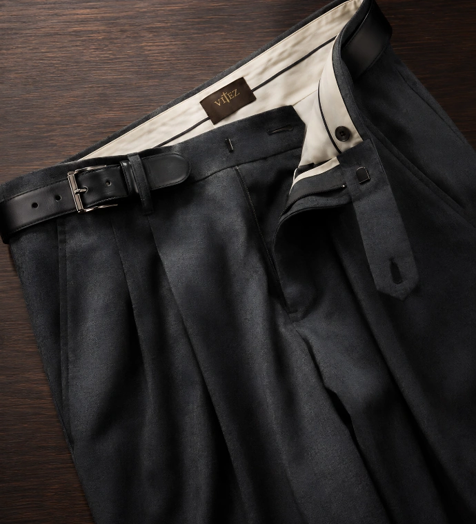 Crne pantalone sa kaisem na drvenoj podlozi